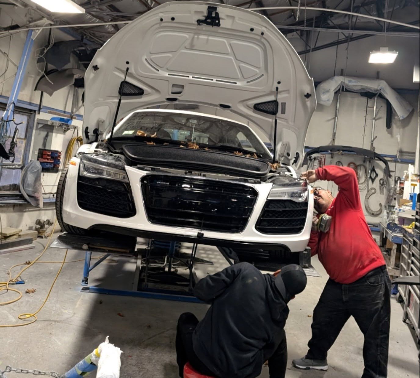 Technician performing frame alignment on a damaged vehicle at SK Auto Body near Pelham, NH