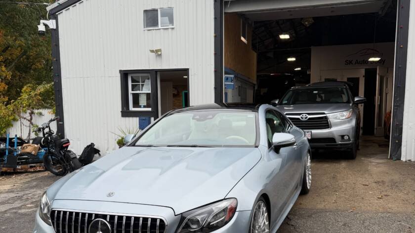 Technician reviewing a written repair estimate with a customer at an auto body shop near Haverhill, MA